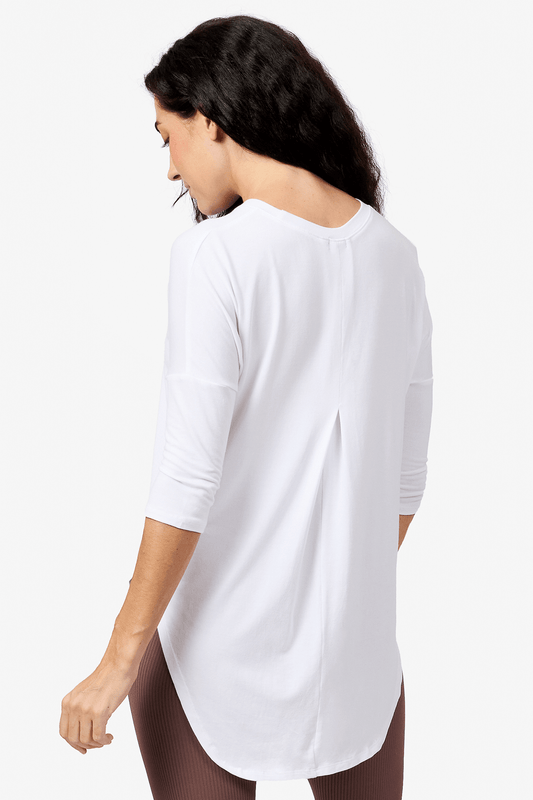 Back of a woman wearing a white 3/4 length sleeve shirt