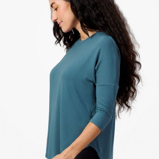 Side of a woman wearing a Teal 3/4 length sleeve shirt