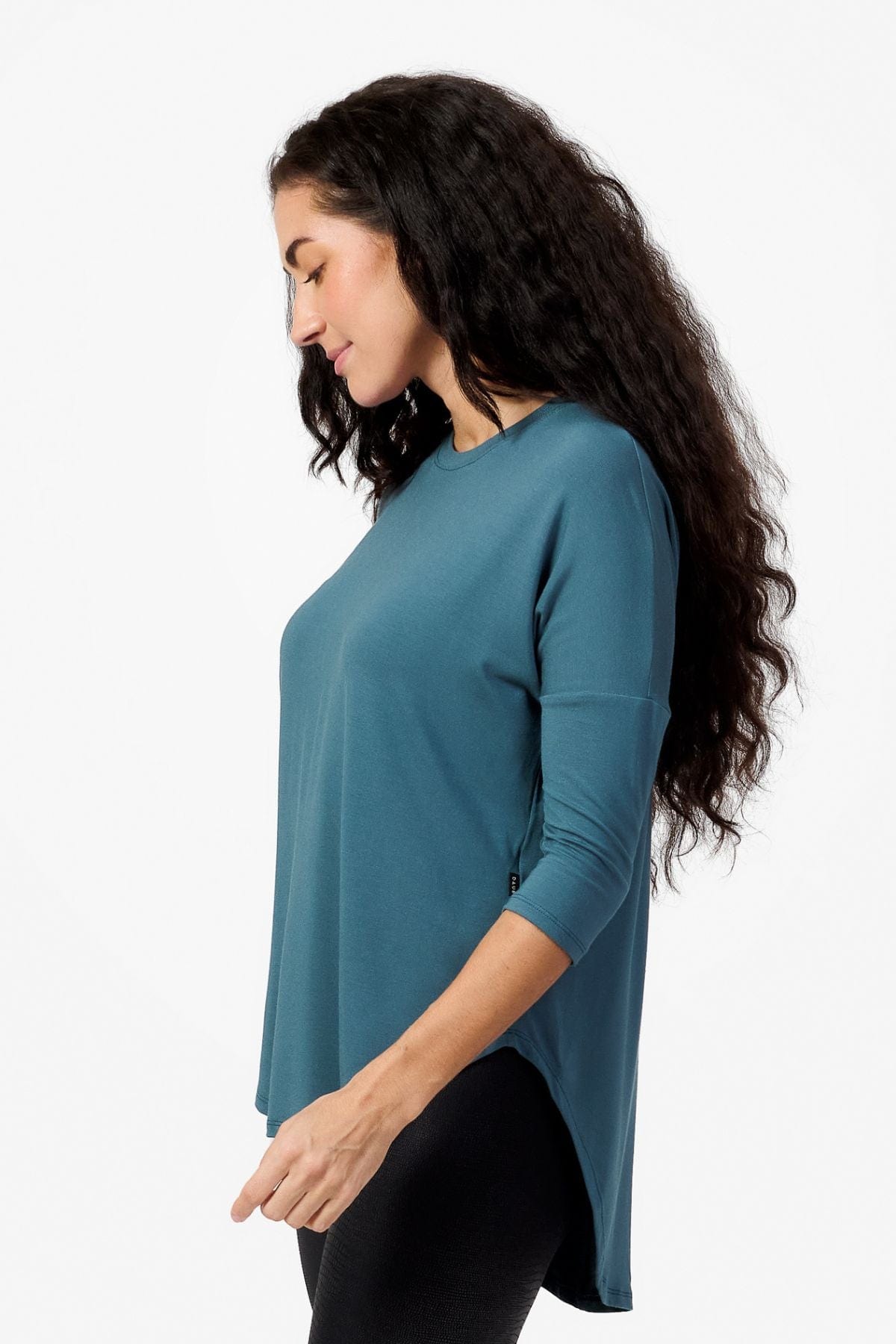 Side of a woman wearing a Teal 3/4 length sleeve shirt