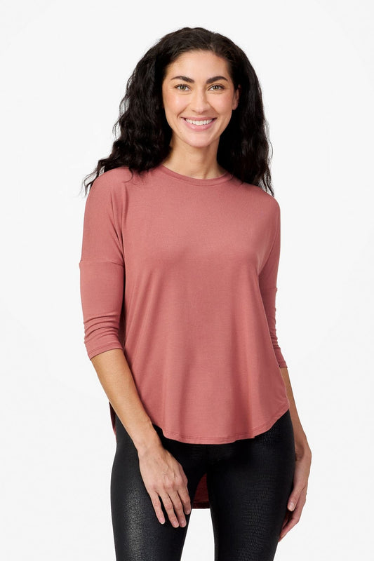 Woman smiling wearing a light rust 3/4 length sleeve shirt 