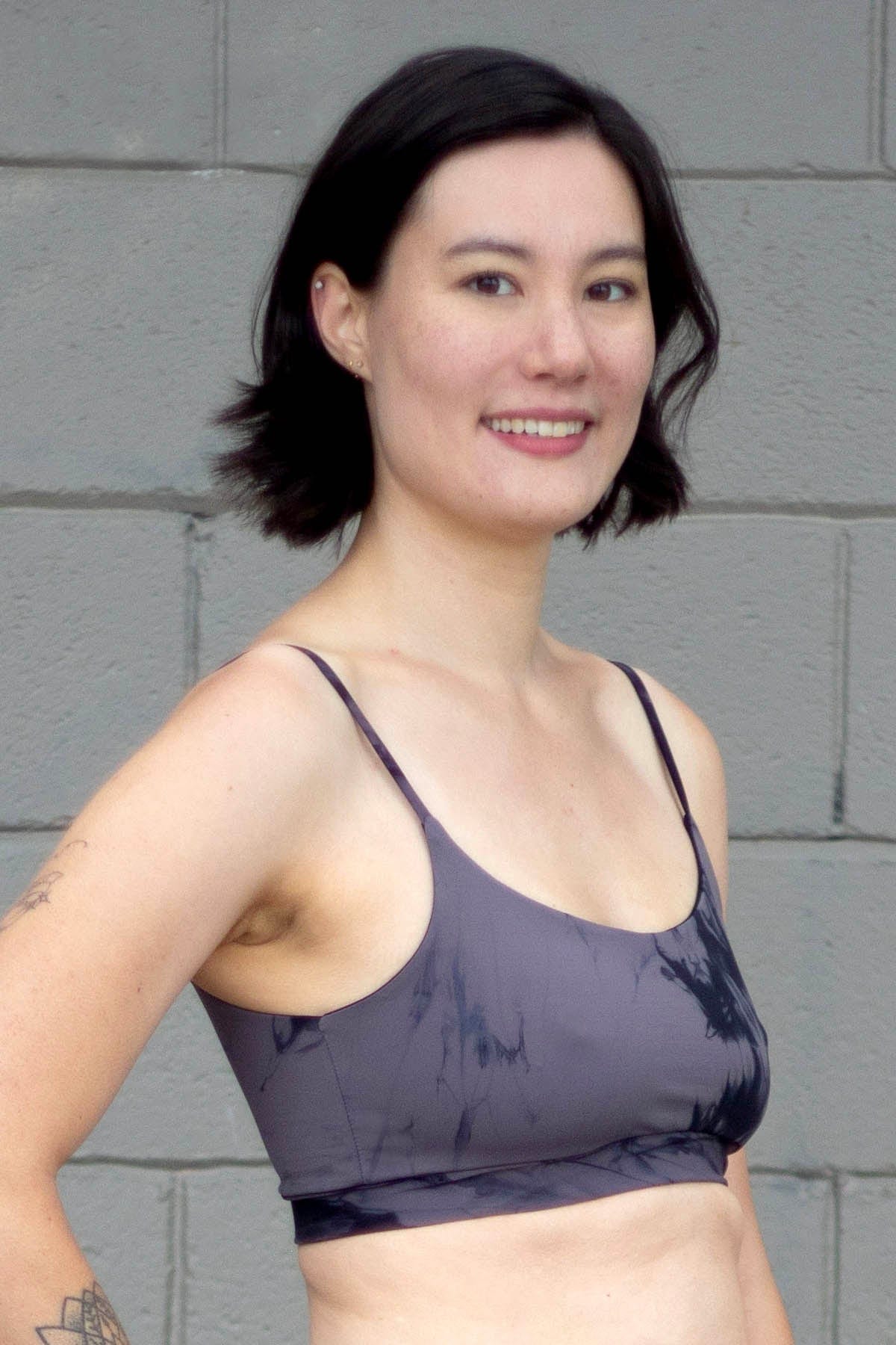 Woman smiling wearing a tie-dye grey swim top