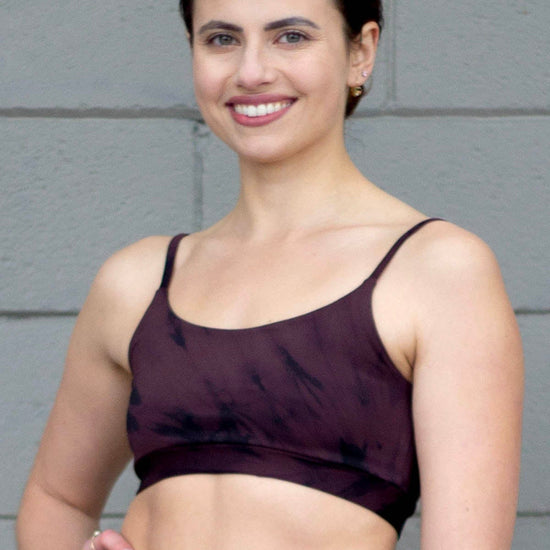 Woman smiling wearing a brown tie-dye swim top
