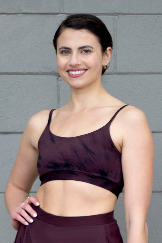 Woman smiling wearing a brown tie-dye swim top