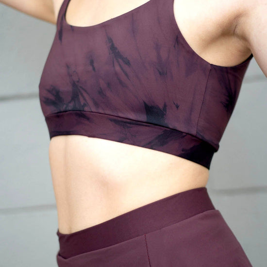 The torso of a woman wearing a swim top tie-dye