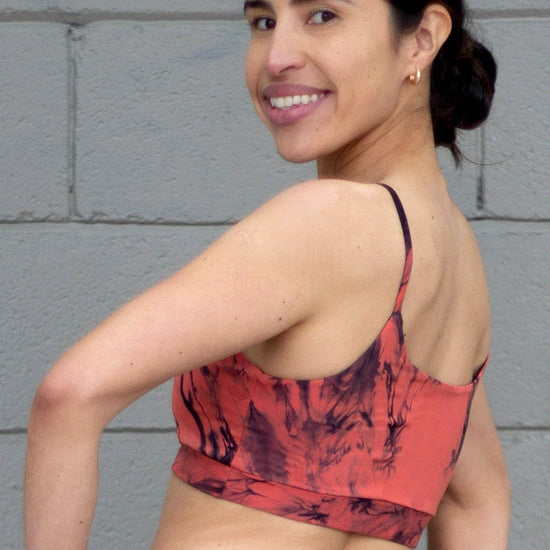 The back of a woman wearing an orange tie-due swimsuit top