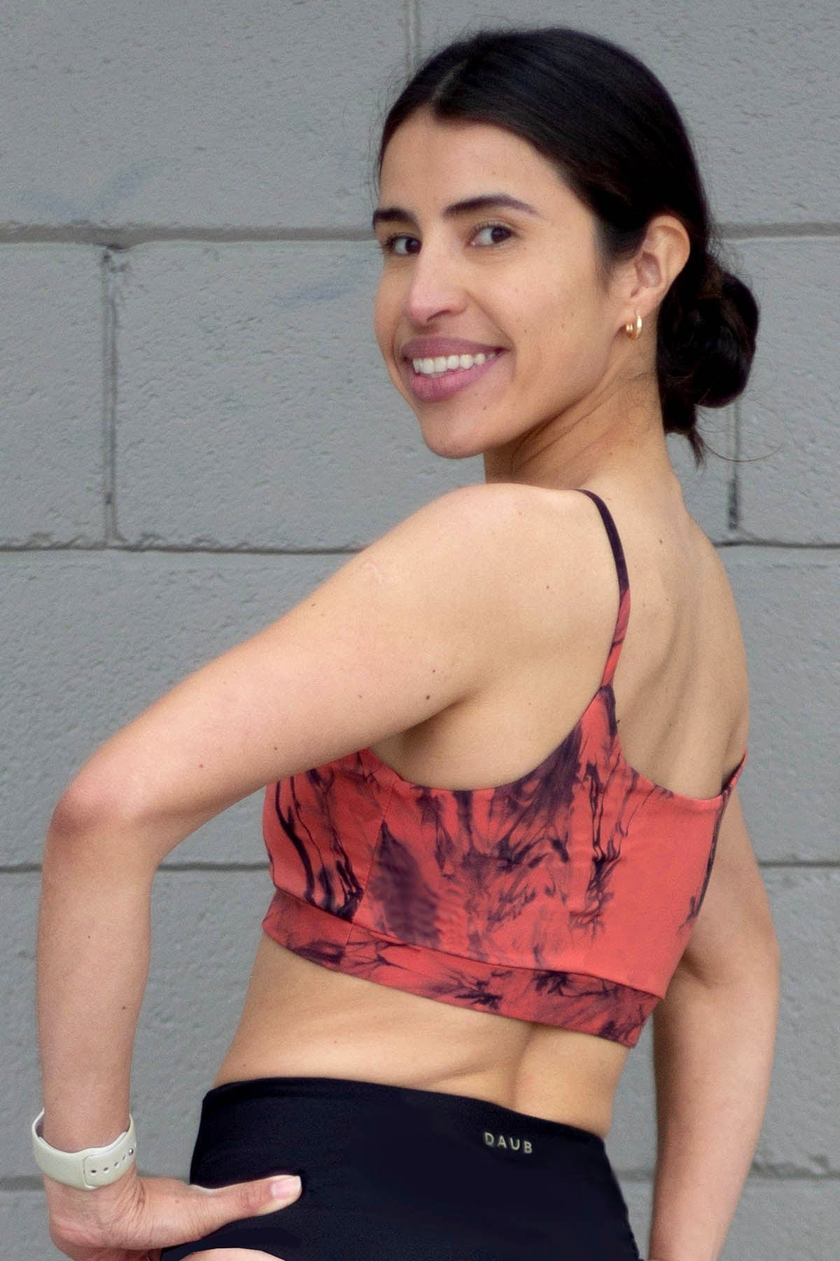 The back of a woman wearing an orange tie-due swimsuit top