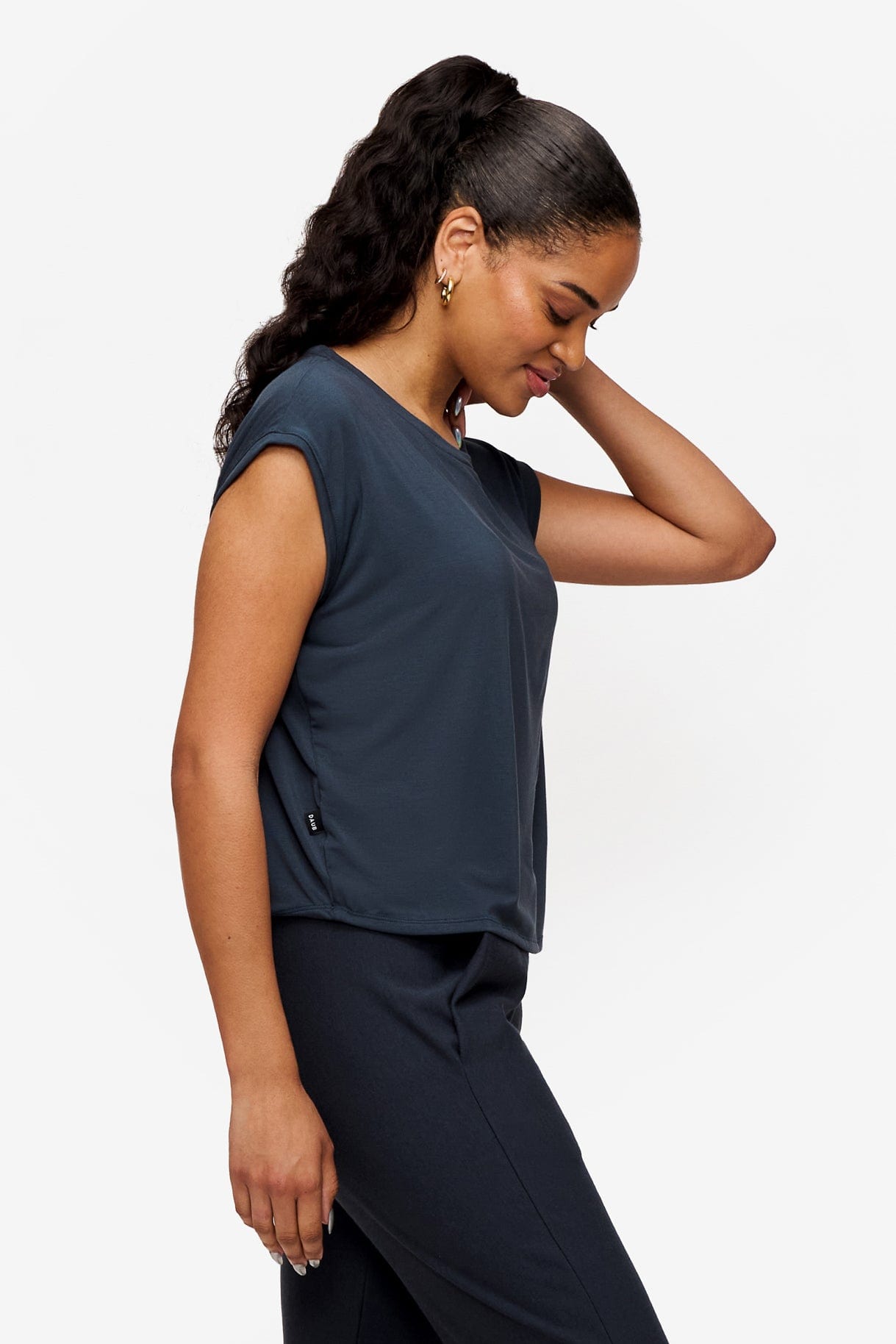 side of a woman wearing a sleeveless top in dark blue