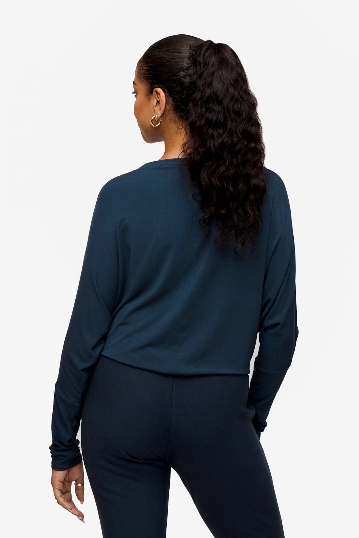Back of a Woman wearing a long sleeve tee with dolman sleeves tucked in