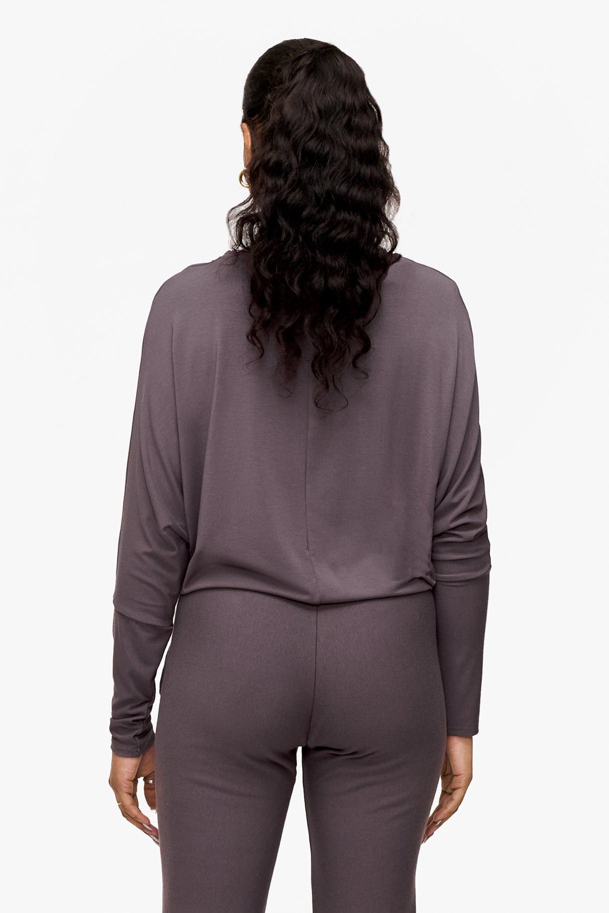 back of a woman wearing a deep purple loose sleeve long sleeve shirt