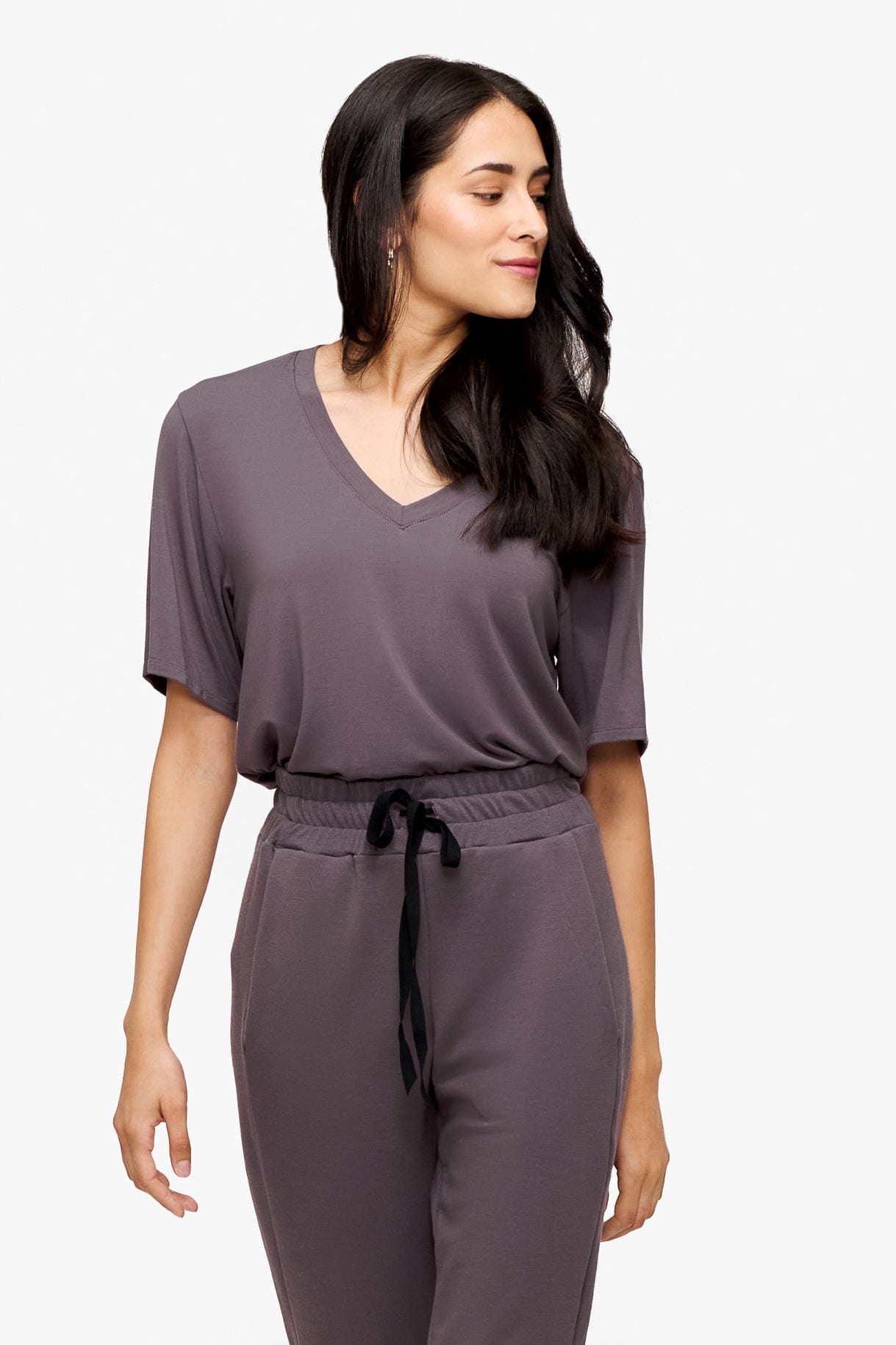 woman wearing deep purple v-neck short sleeve t-shirt tucked in matching pants