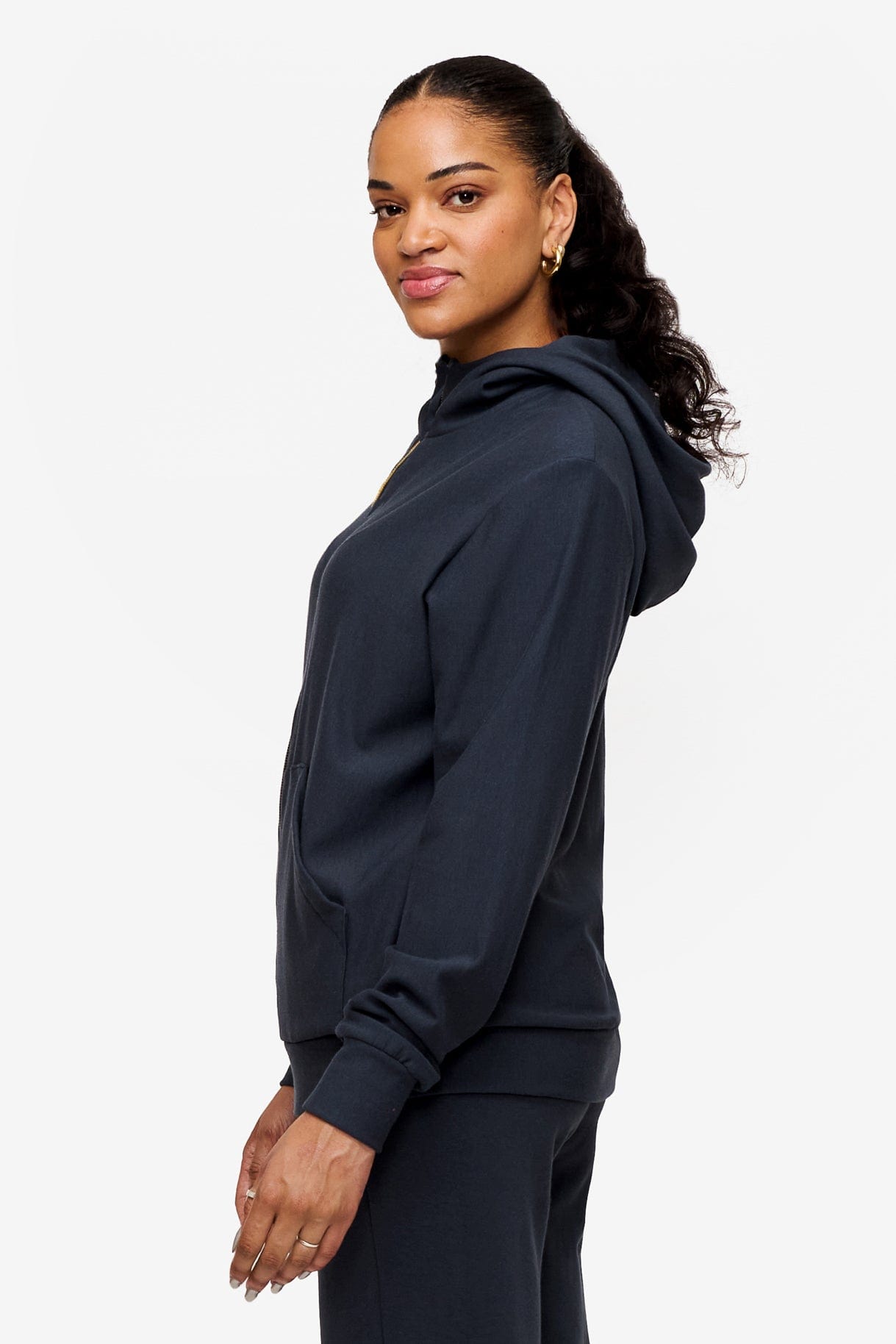 side of a woman wearing full zip hoodie in dark blue