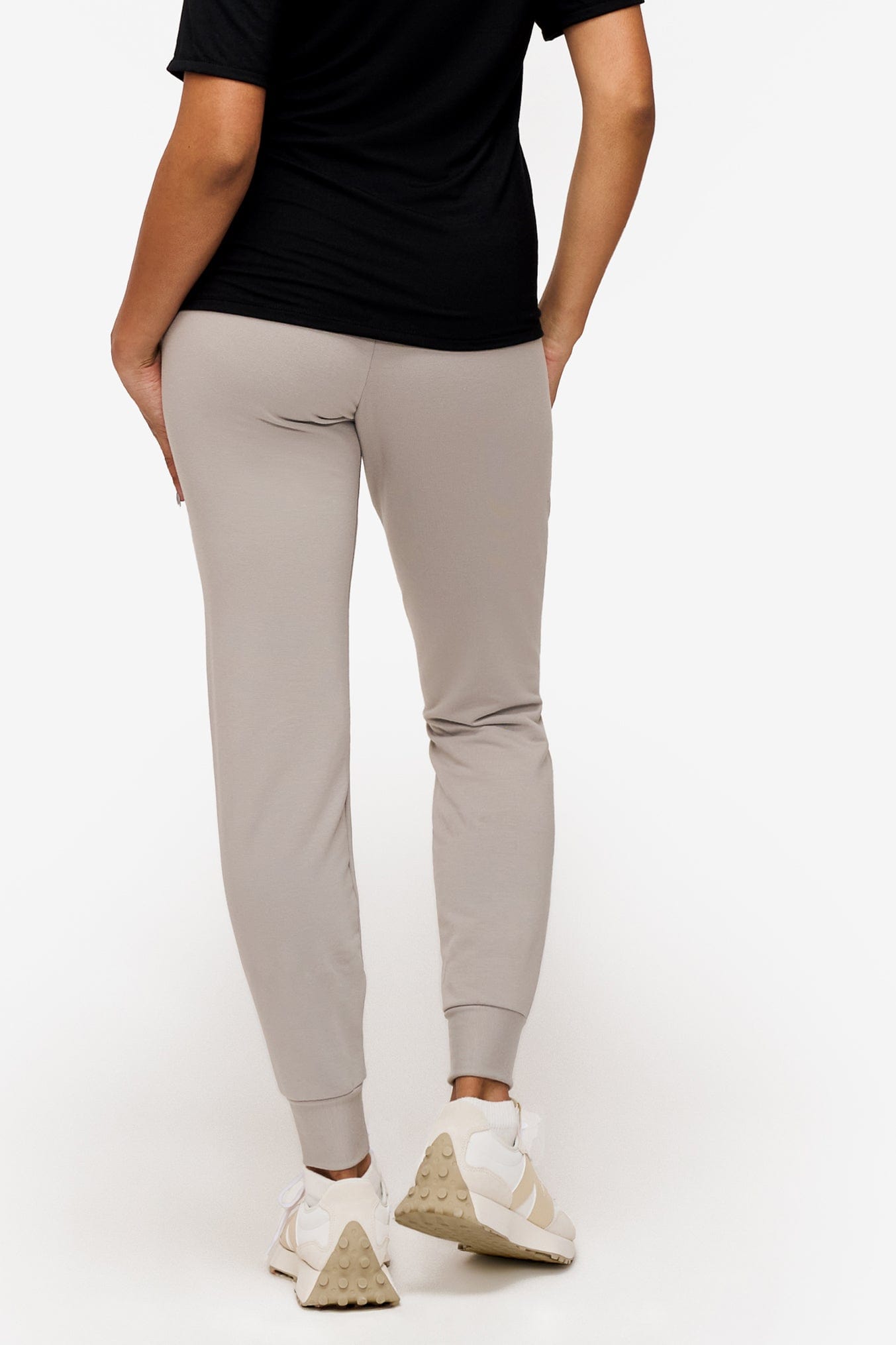 back of a woman wearing light grey sweatpants