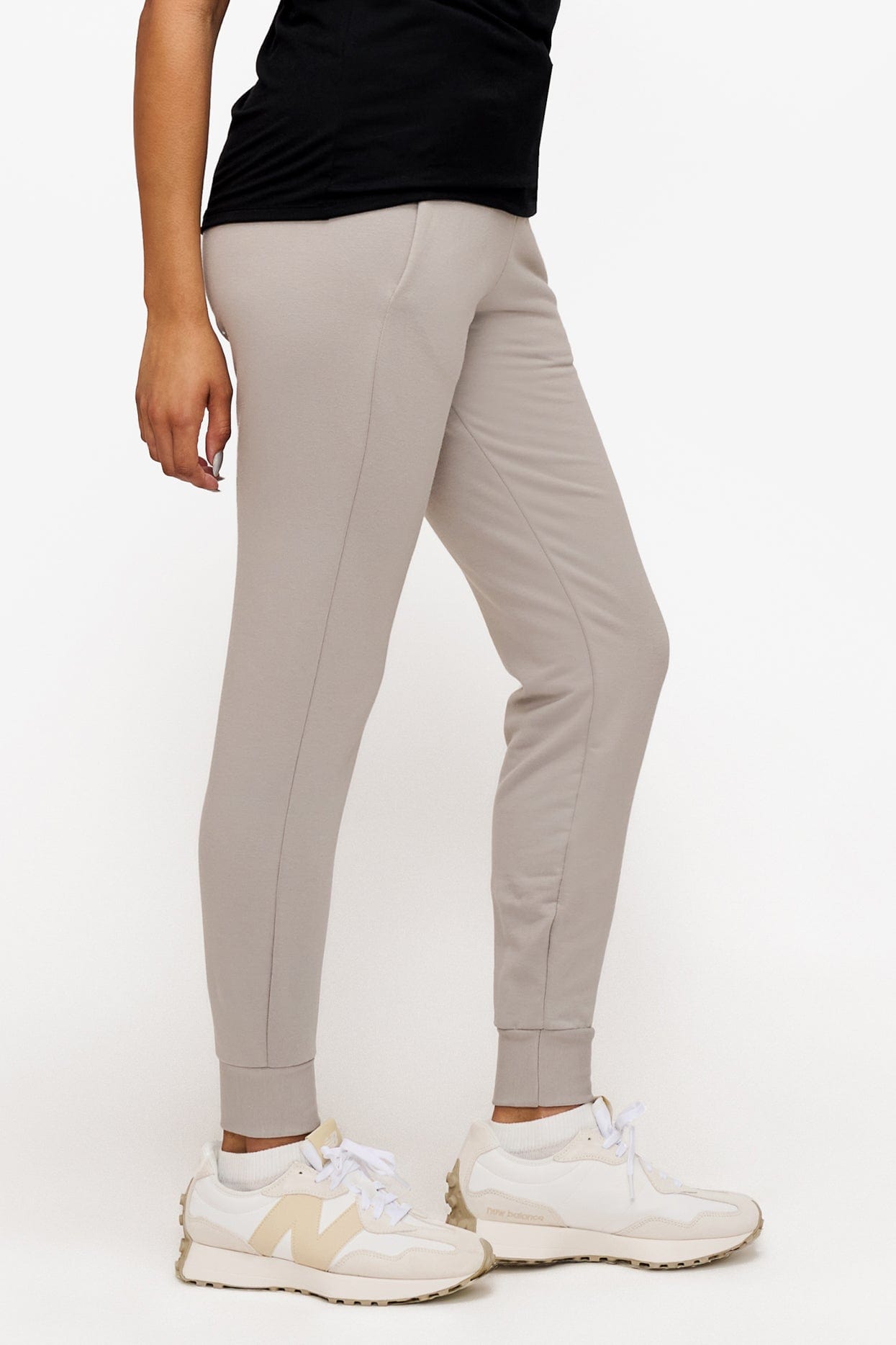 side of a woman wearing light grey sweatpants