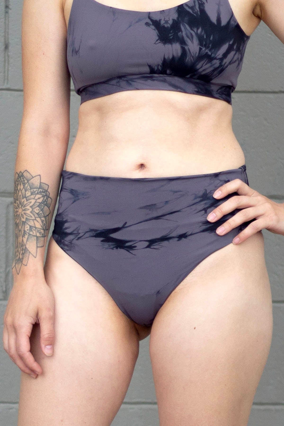 Woman wearing matching swimsuit in grey tie-dye