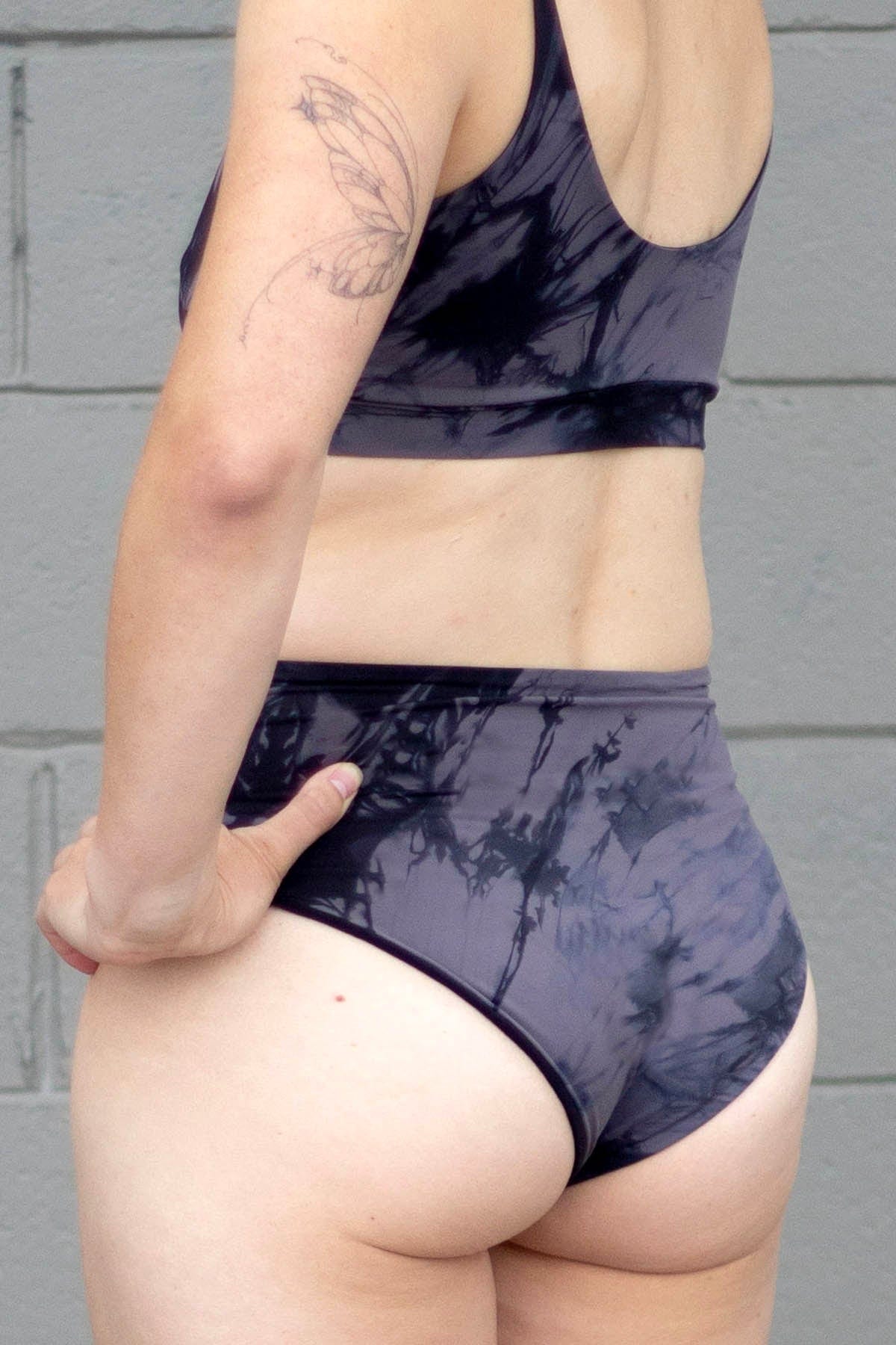 Back of a woman wearing grey tie-dye swim bottoms