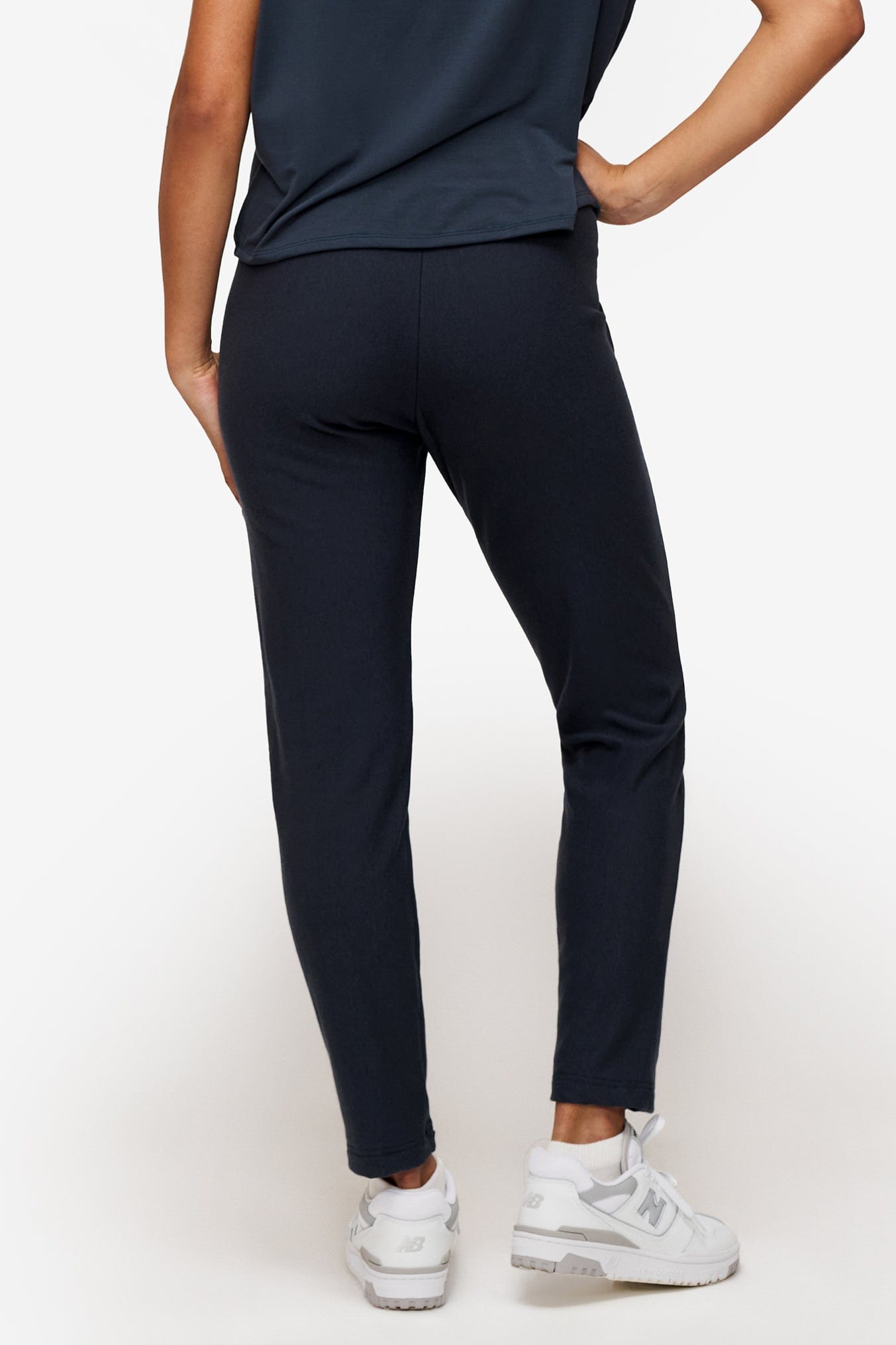 back of a woman wearing dark blue dressy pants