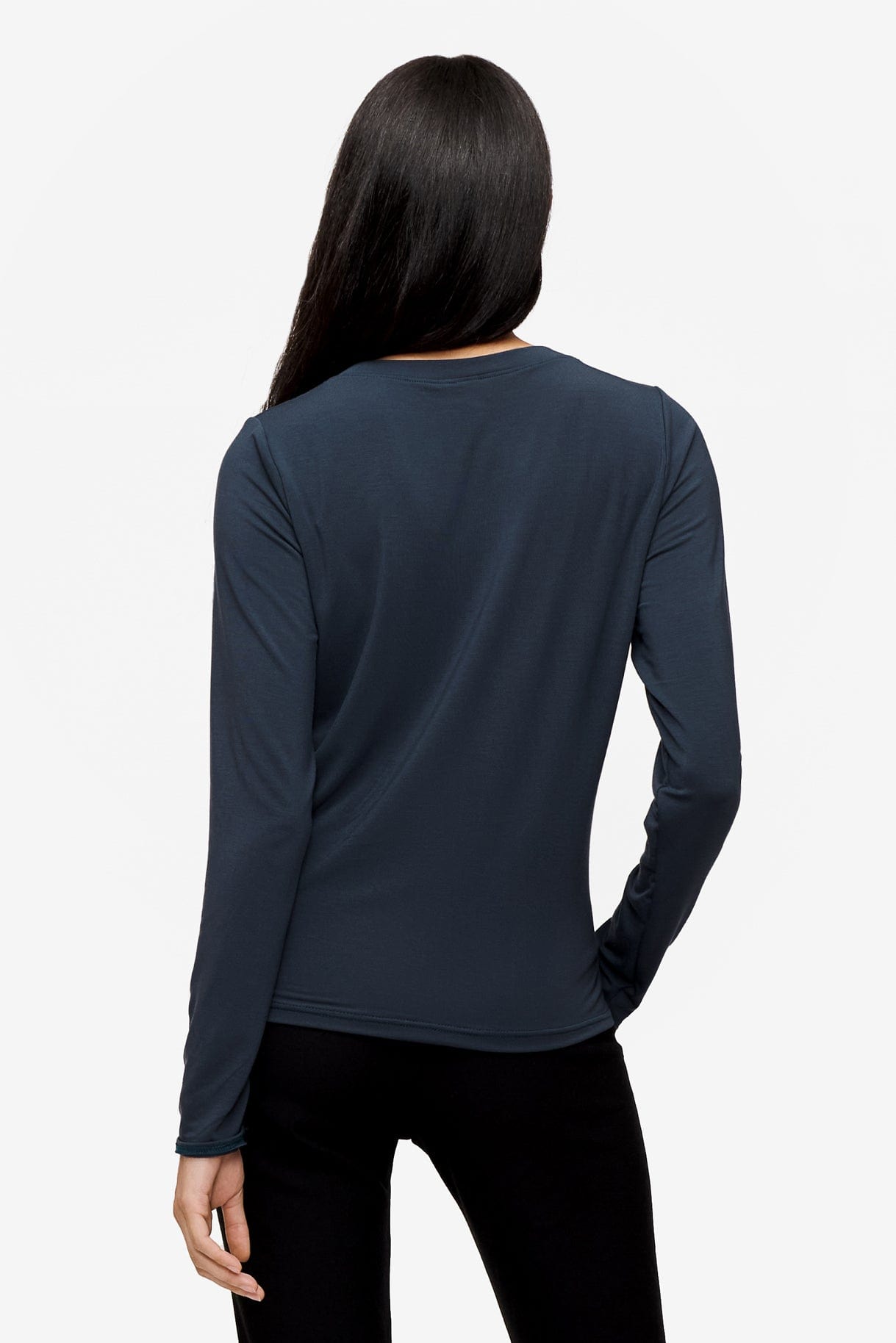 back of a woman wearing a long sleeve shirt with a twist at the front in dark blue