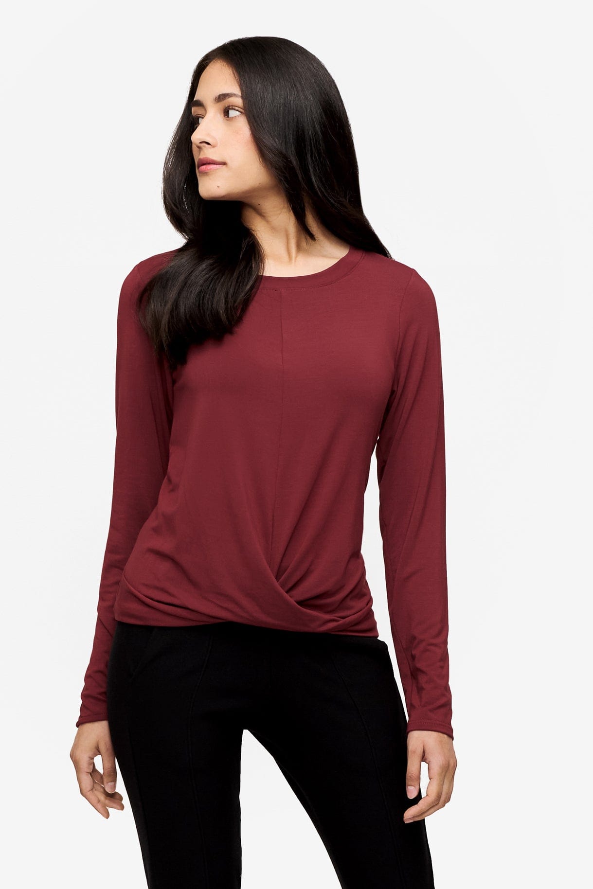 woman wearing a long sleeve shirt with a twist at the front in deep red