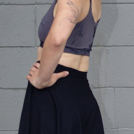 Side of a woman wearing a black tennis skirt