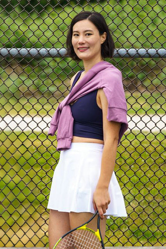 Woman wearing a white tennis skirt while playing tennis