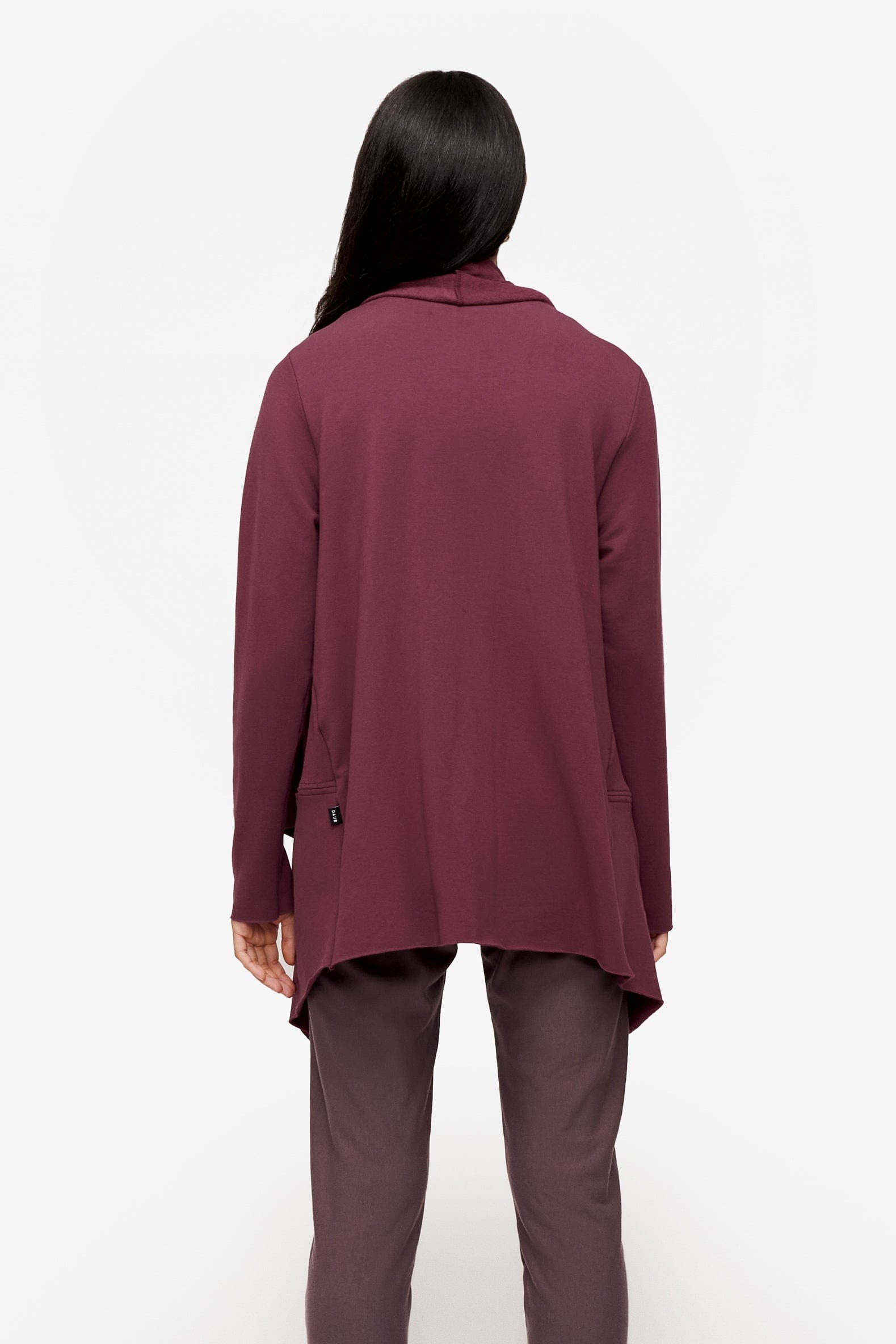 back of a woman wearing a drapey jacket in deep pink