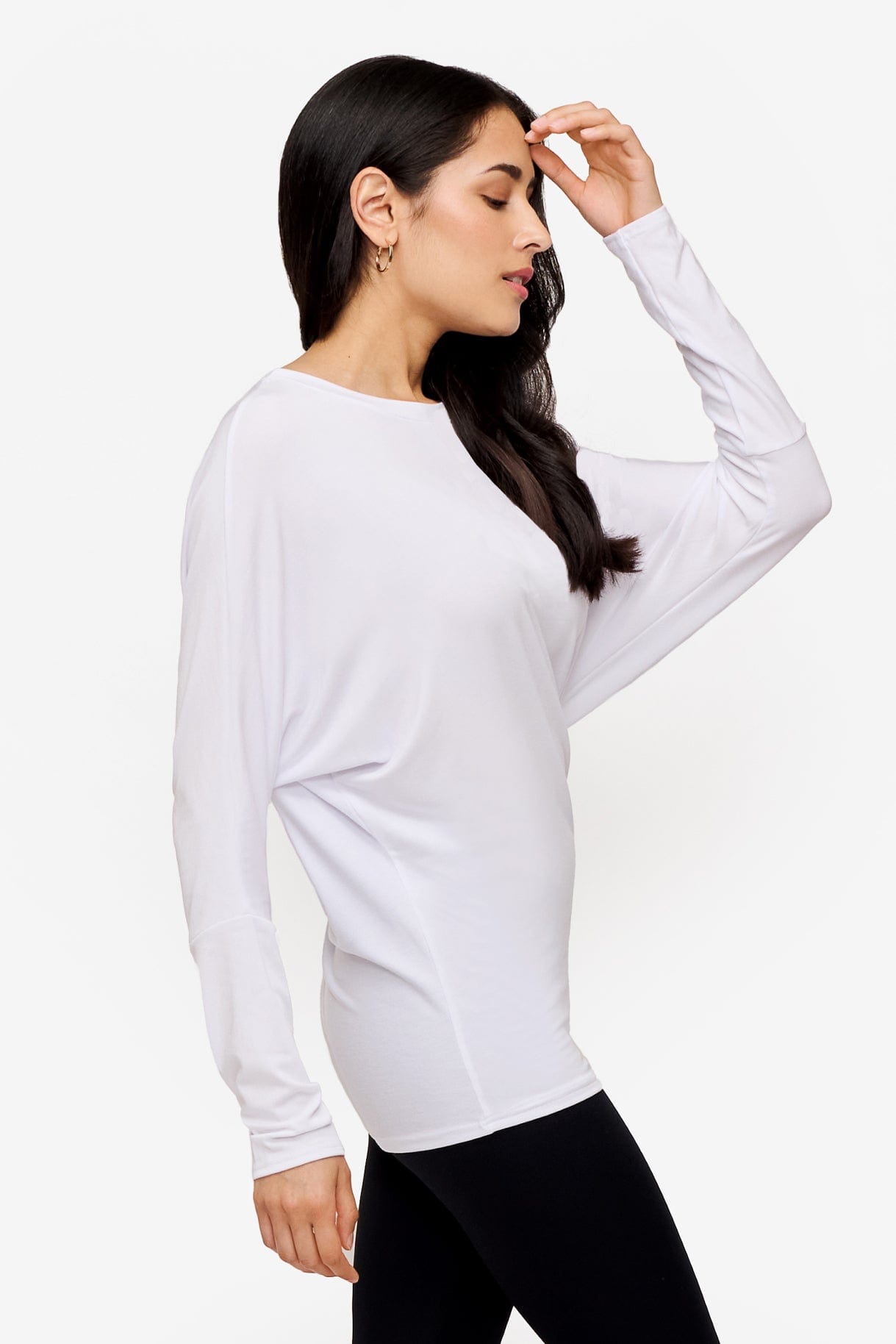 profile of a woman wearing a white loose sleeve long sleeve shirt