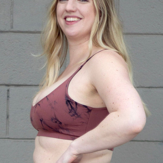 Side of a woman wearing a pink tie-dye swim top