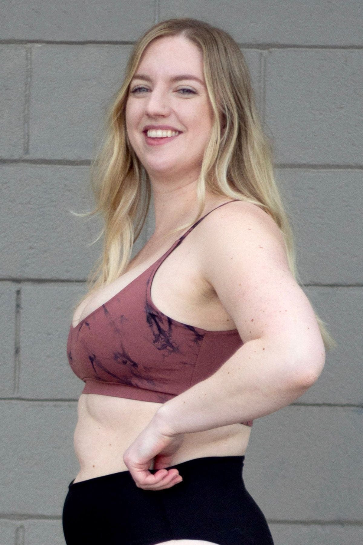 Side of a woman wearing a pink tie-dye swim top