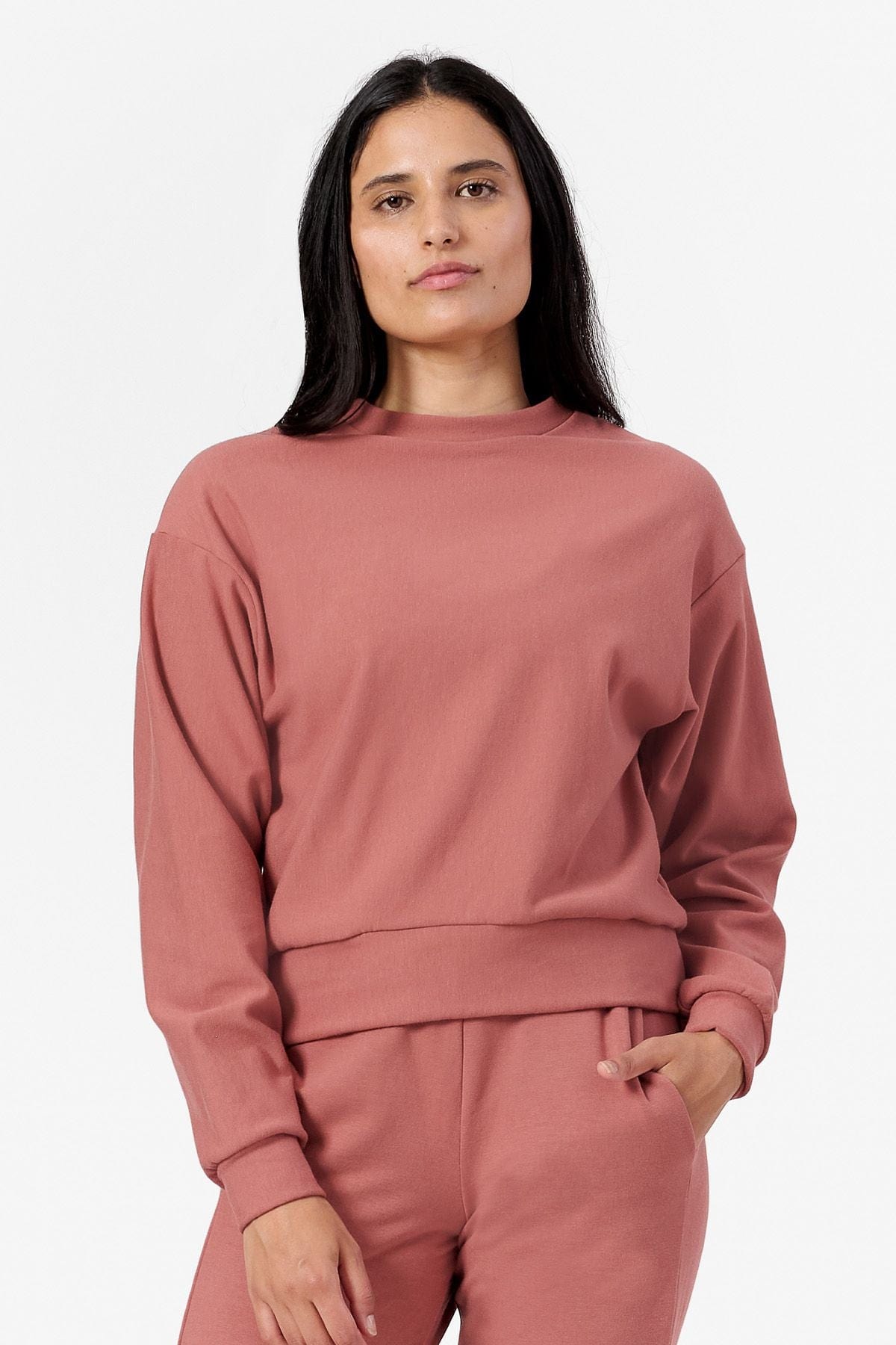 Woman wearing a light rust crew neck