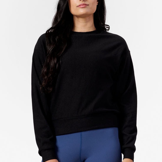 Woman wearing a black crew neck sweatshirt