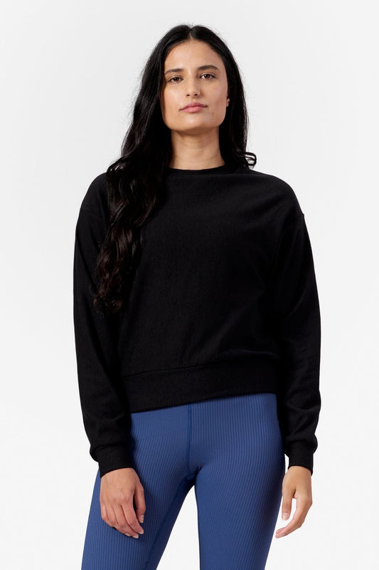 Woman wearing a black crew neck sweatshirt