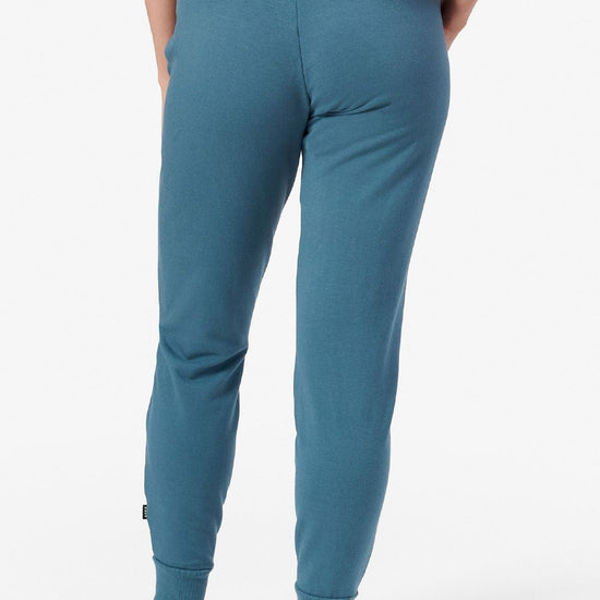 Back of a woman wearing teal joggers