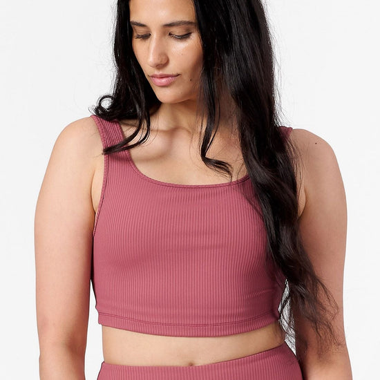 front view of a woman wearing a square neck ribbed sports bra in pink 