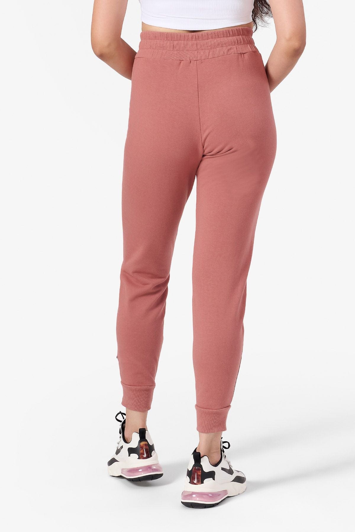 Back of a woman wearing light rust joggers
