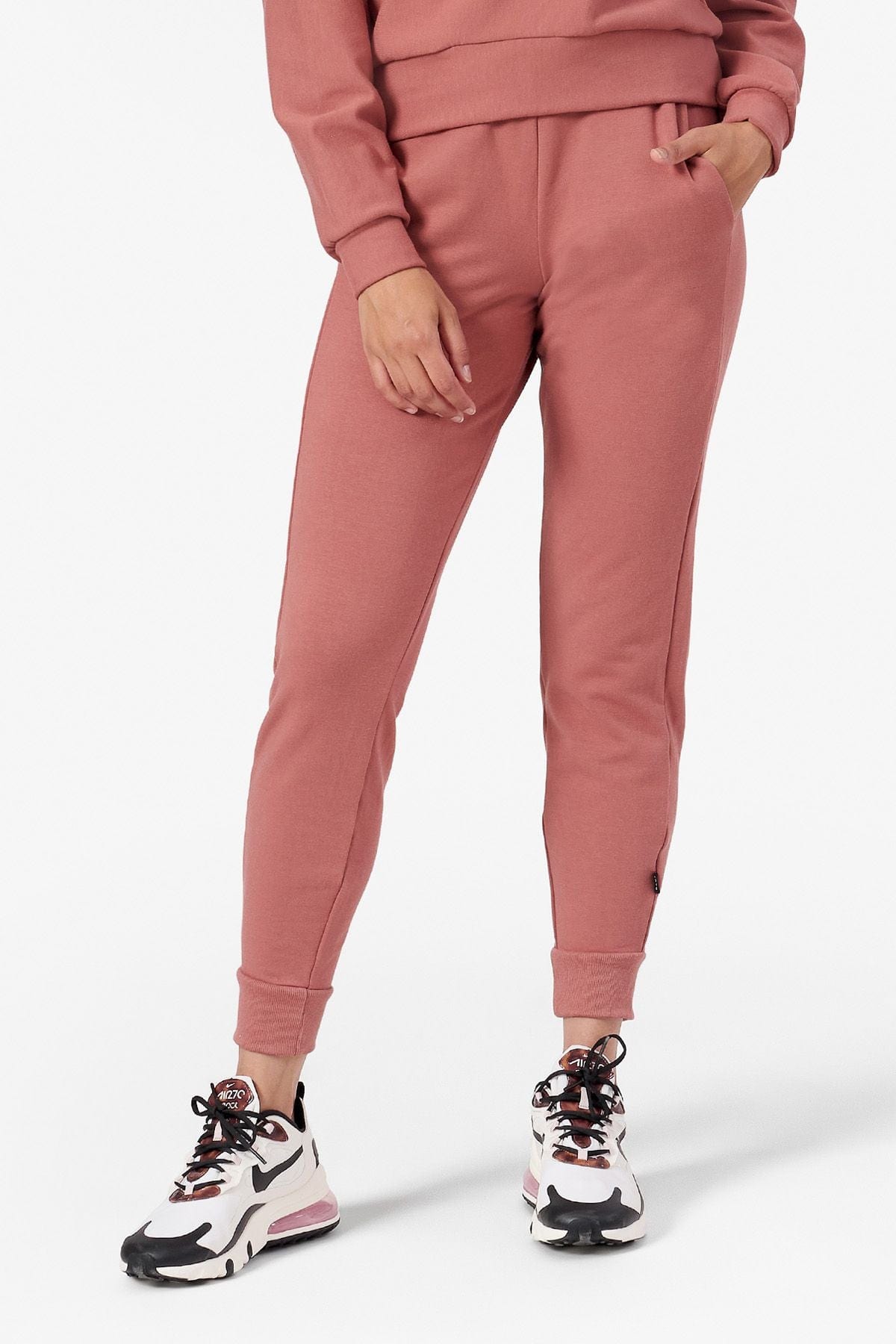 Woman wearing light rust joggers and matching top