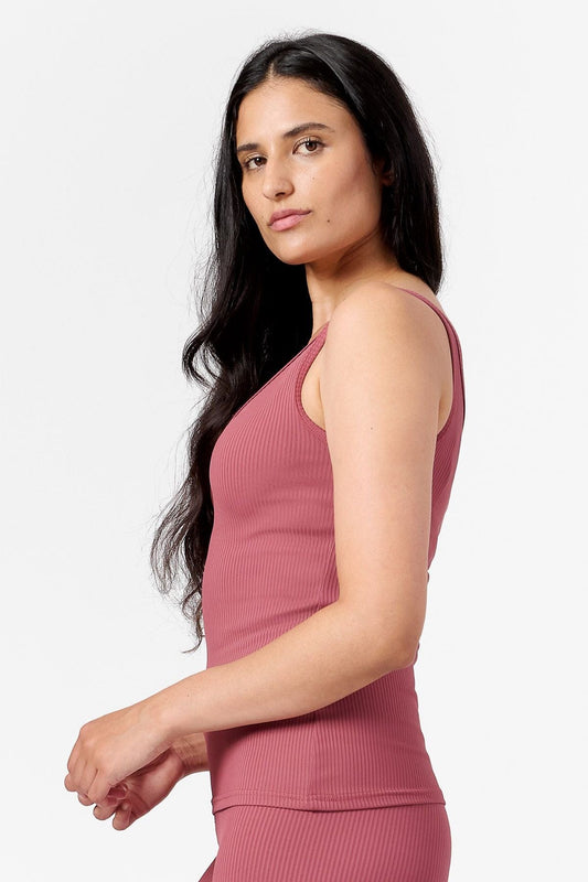 side view of a woman wearing a pink ribbed tank top