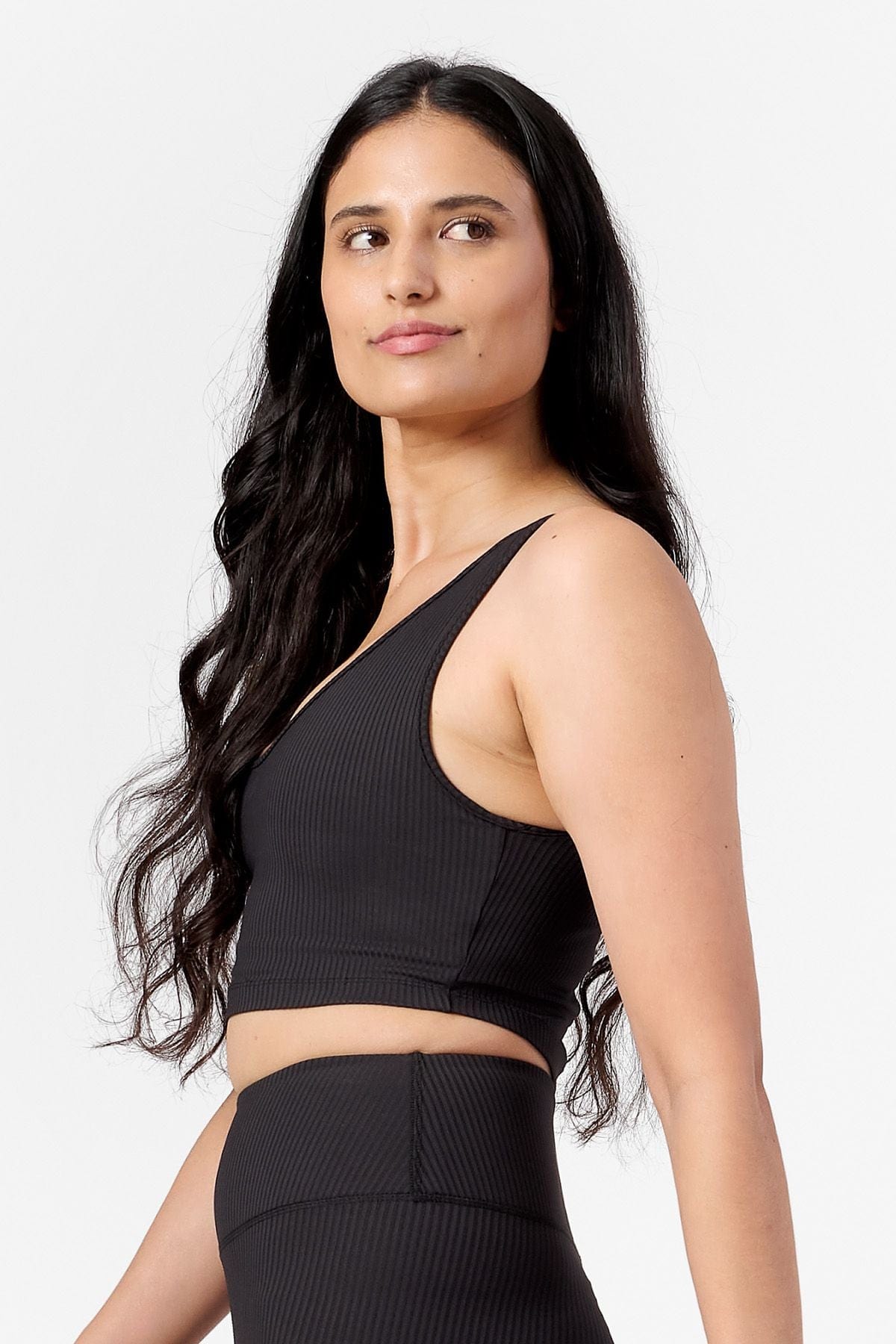 woman wearing reversible black ribbed bra. side view