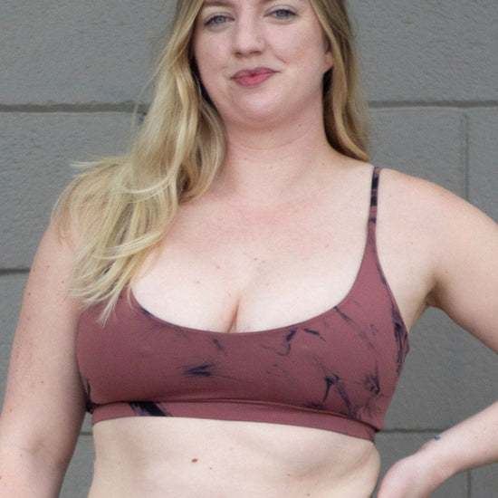 Blonde woman wearing a tie-dye swim top