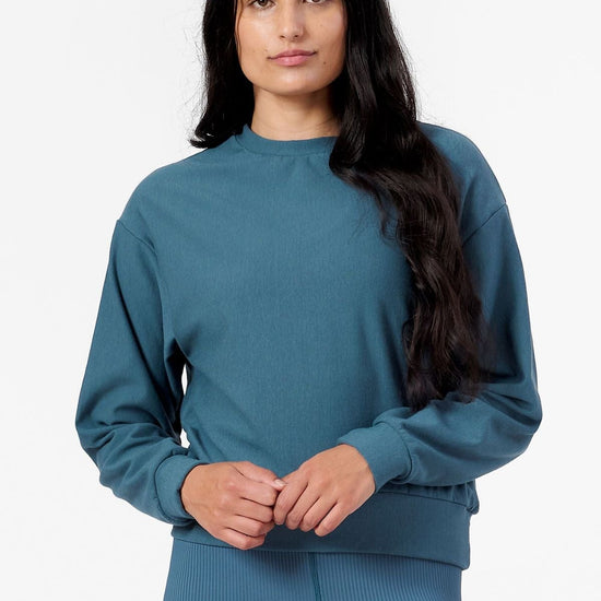 Woman wearing teal sweatshirt