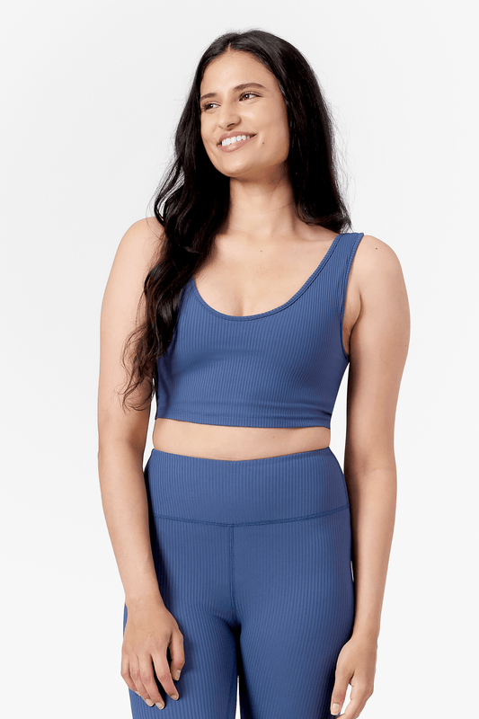 Woman wearing scoop side of a reversible ribbed sports bra in blue