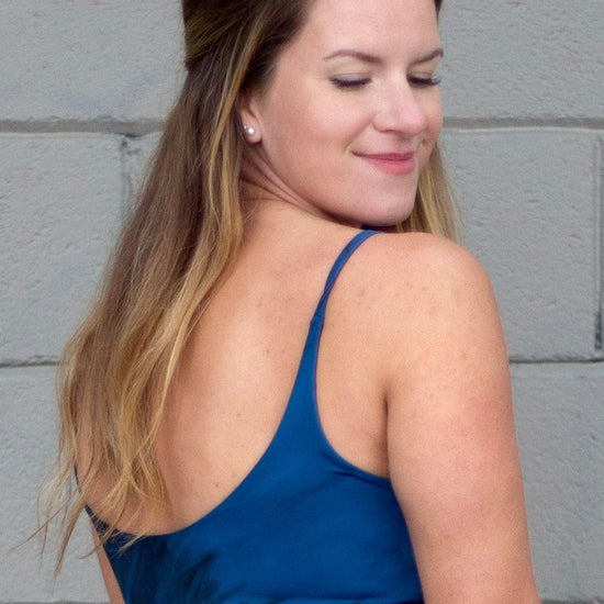 Back of a woman wearing blue and black tie dye swim top