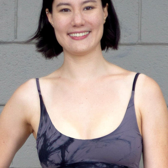 Woman wearing a grey tie dye swim top with skinny straps