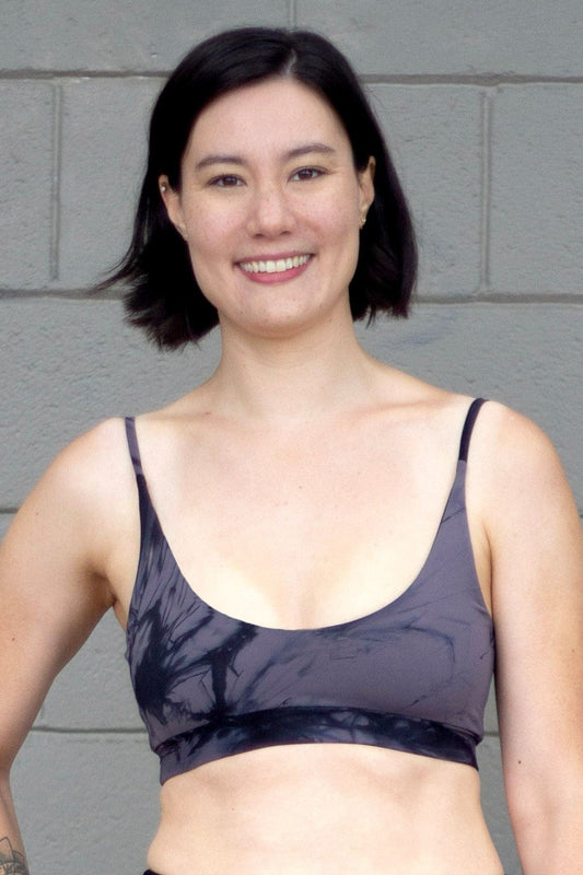 Woman wearing a grey tie dye swim top with skinny straps