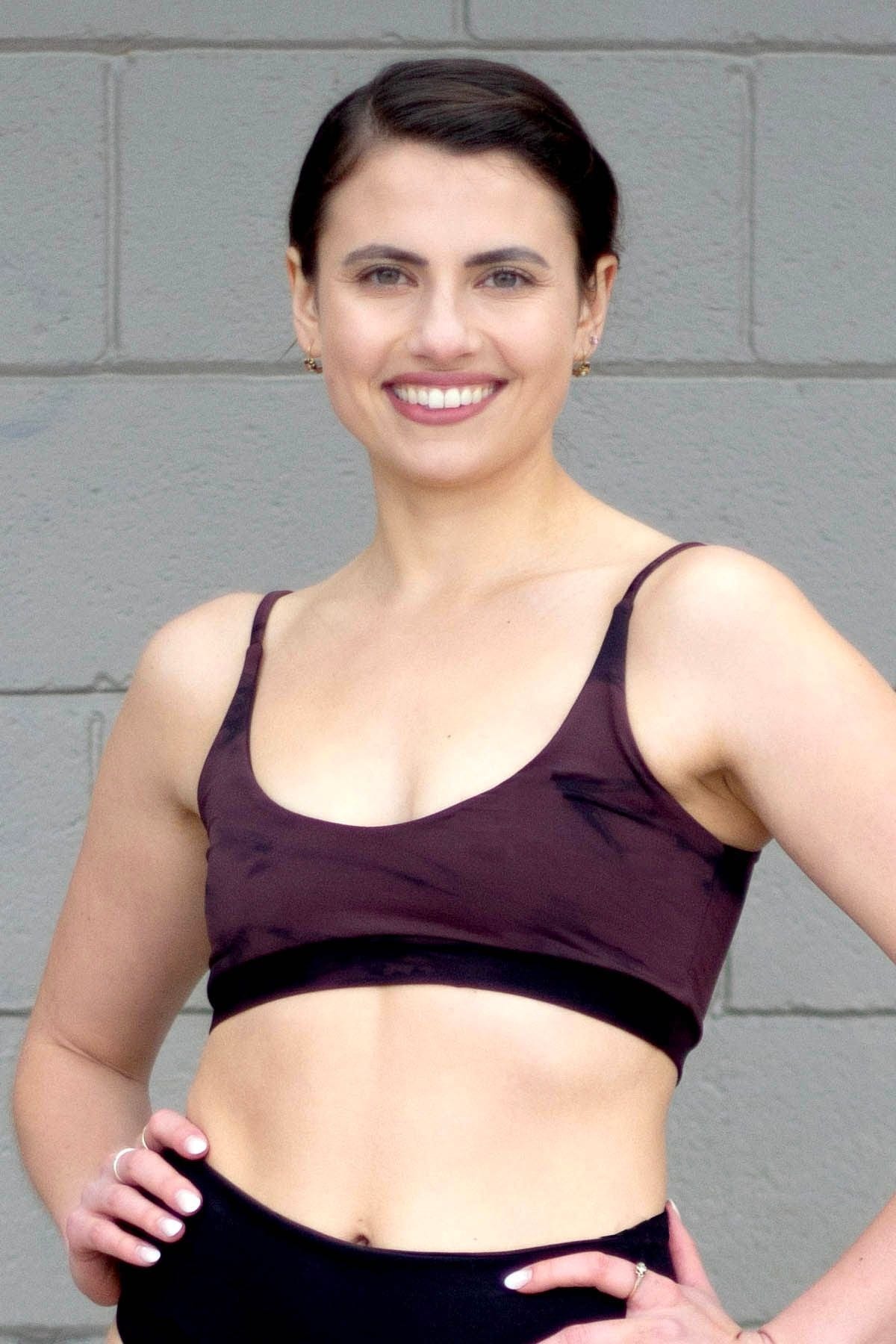 Woman wearing tie-dye swim top and black high-waisted swim bottoms