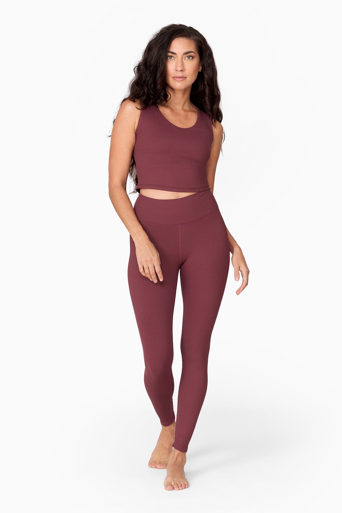 a tall slender woman with waist length hair wears a brownish tank top with matching ribbed leggings