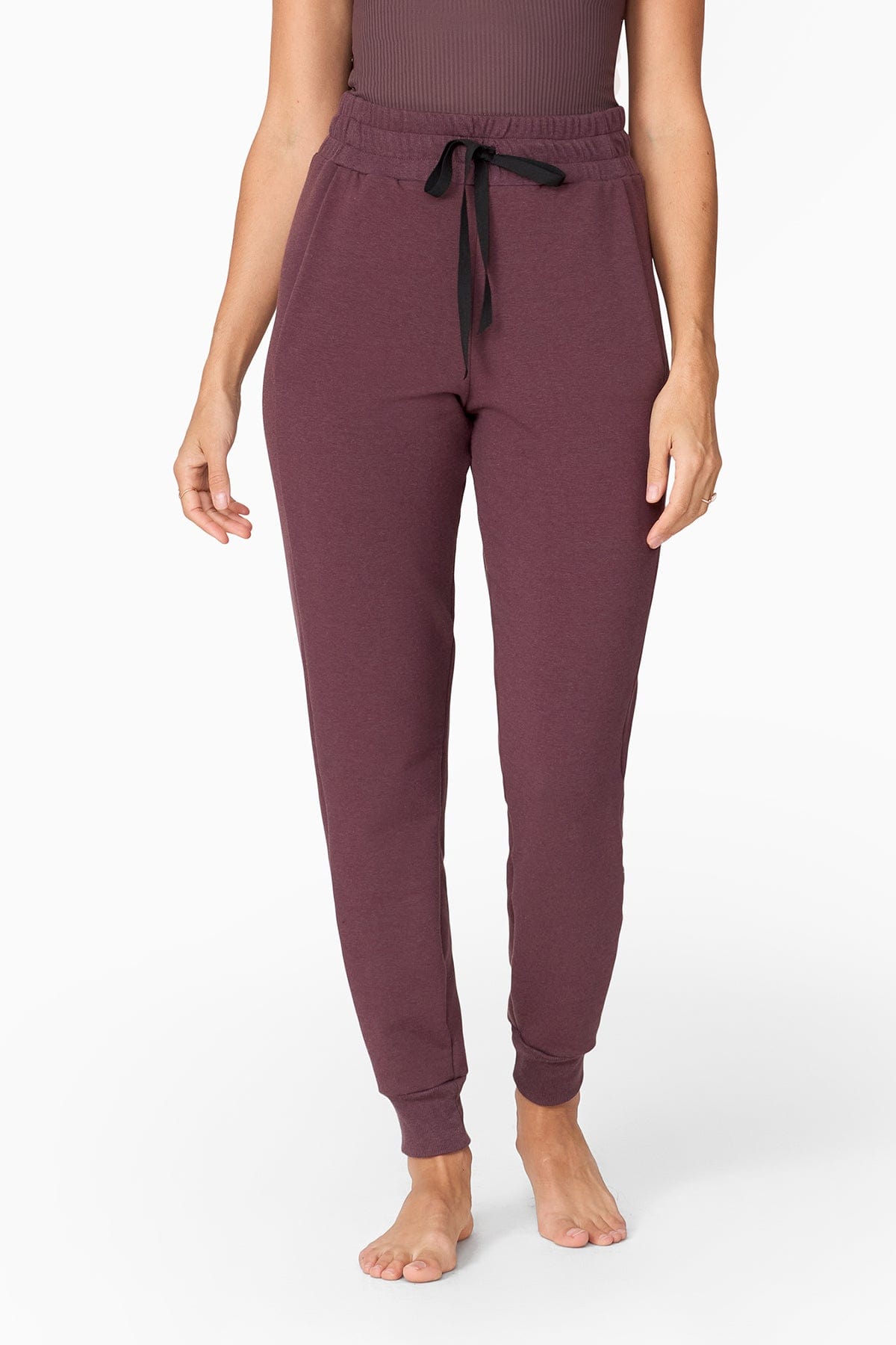 woman wearing a brownish purple jogger with tied up black laces at the front of her waistline.