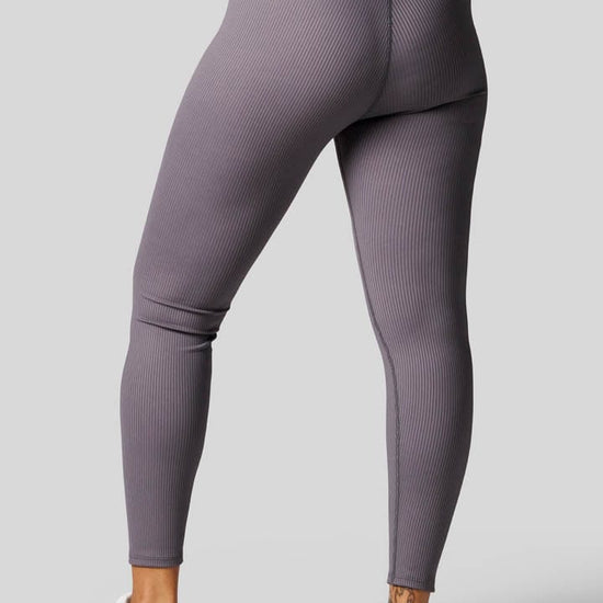 Back of a woman wearing grey ribbed leggings 