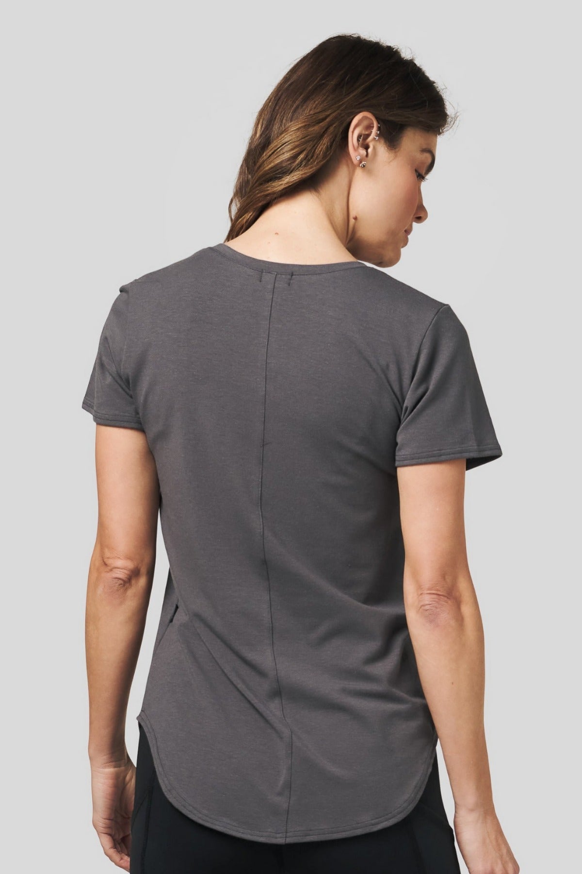 Back of a women wearing a dark grey short sleeve tee.