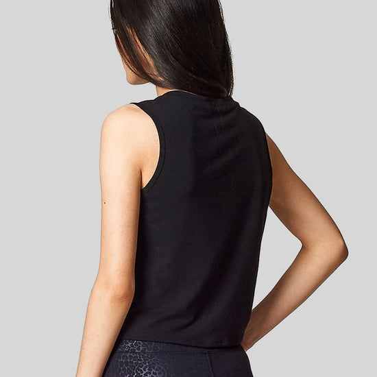 The back view of a sleeveless tank in black worn with black cheetah print leggings.