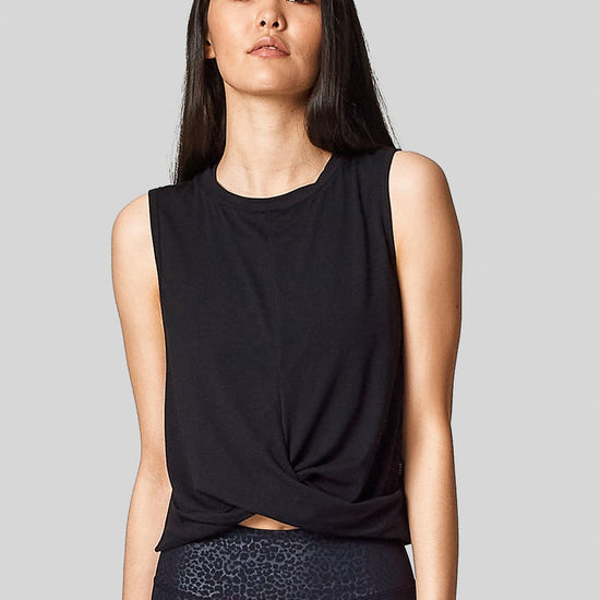 A black sleeveless tank with criss cross twisty front. Slightly cropped.